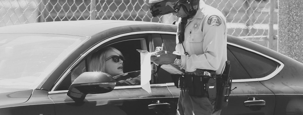 Officer writing driver a traffic violation ticket