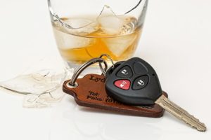 Broken glass of alcohol sitting beside car keys