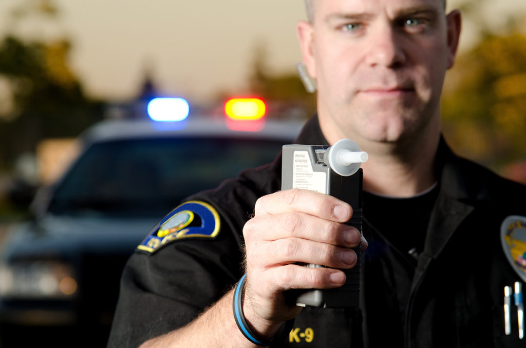 cop holding dui dwi breathalyzer