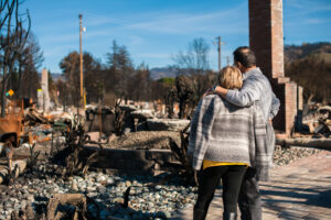 Northern CA wildfire man and woman surveying damaged property